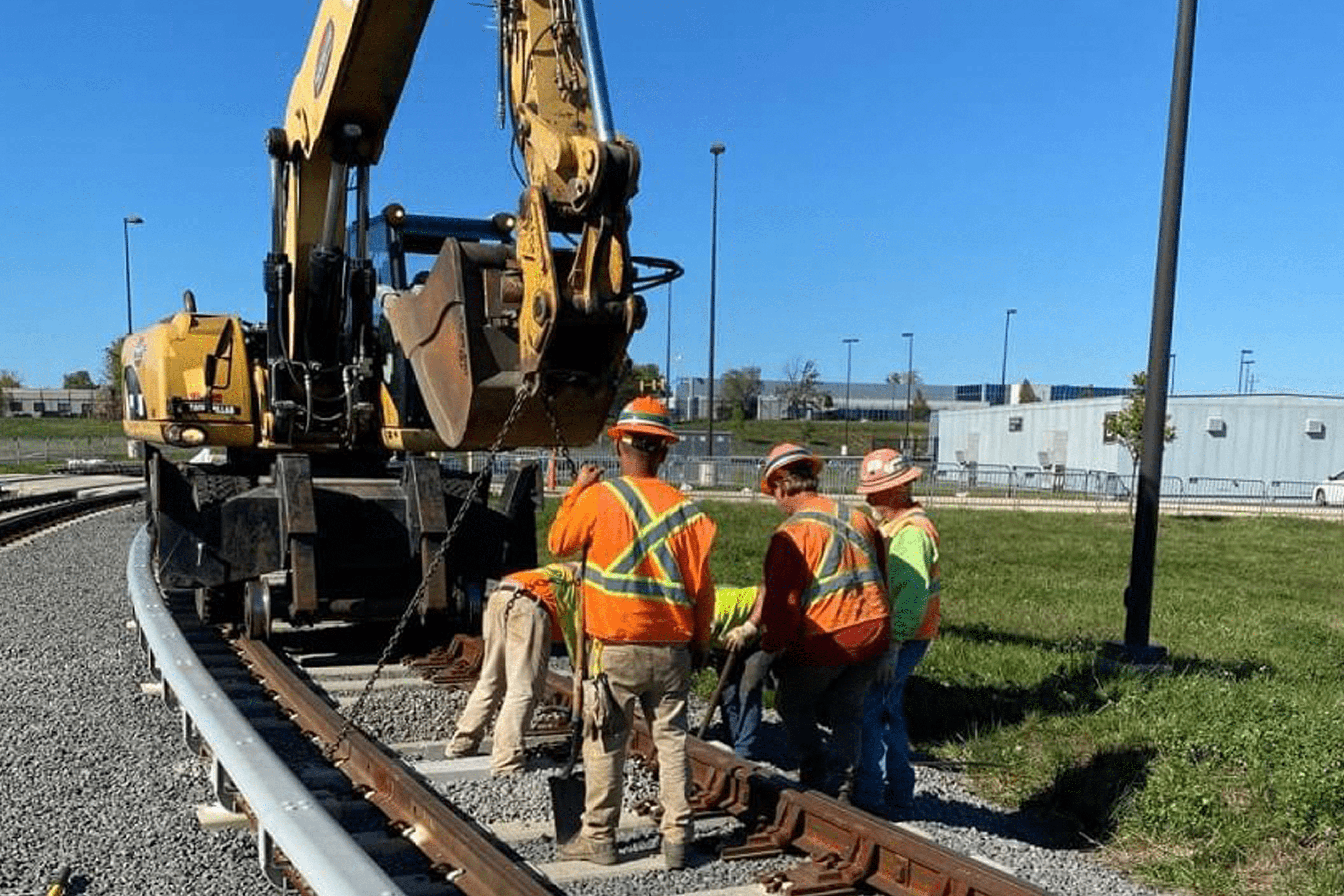 A Group Of Men Standing Next To A Train Track